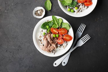 Sağlıklı öğle yemeği. Ton balığı, yabani pirinç ve kase hizmet içinde basmati, domates, ıspanak ve yeşil bezelye. Üstten Görünüm.