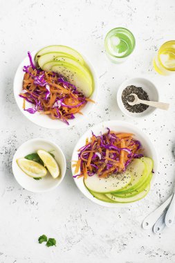 Elma, havuç, lahana, kereviz ve ahşap zemin üzerine limon ile taze salata kapatın. Sağlıklı gıda