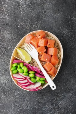 Taze deniz ürünleri yemek tarifi. Taze karides, kahverengi pirinç, salatalık, turşu tatlı soğan, turp, soya fasulye edamame siyah beyaz susam ile alakart bir somon poke kase karides. Gıda kavramı poke kase