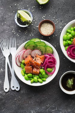 Taze deniz ürünleri yemek tarifi. Taze karides, kahverengi pirinç, salatalık, turşu tatlı soğan, turp, soya fasulye edamame siyah beyaz susam ile alakart bir somon poke kase karides. Gıda kavramı poke kase