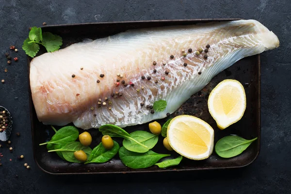 Filé de bacalhau fresco de peixe marinho branco antes de cozinhar com sal marinho, azeite, ervas e pimenta. Conceito de alimentação saudável — Fotografia de Stock