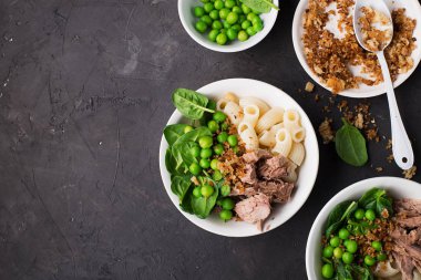 Ton balığı makarna kasesi salatası. Taze ıspanak, taze bezelye ve ekmek kırıntılarıyla. Üst Manzara. Düz yatıyordu