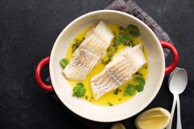 Buharda pişirilmiş balık fileto tereyağlı limon sosu ve fırında otlar. Üst Manzara. Fırın kabında. Sağlıklı beslenme,