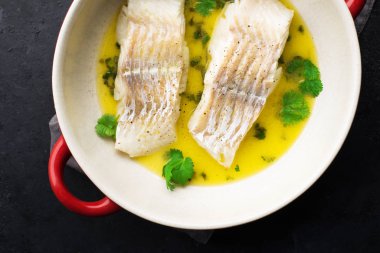 Buharda pişirilmiş balık fileto tereyağlı limon sosu ve fırında otlar. Üst Manzara. Fırın kabında. Sağlıklı beslenme,