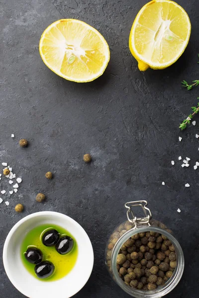 Black food frame background with fresh aromatic herbs and spices, copy space, top view. Allspice, thyme, lemon, olives olives on a dark background — 스톡 사진