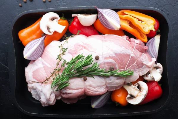 Rolo de porco com verduras em uma folha de cozedura antes de assar. Carne com pimentão doce, cogumelos, cebolas roxas com temperos, pimenta da Jamaica, alecrim, tomilho em um fundo escuro. Vista superior . — Fotografia de Stock