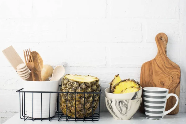 Кухонна полиця спосіб життя білий фон зі свіжими лимонами, ананасами, кухонними інструментами, побутовою технікою, подрібненими дошками, кошиками для зберігання. Екологічно чисте життя. Стиль будинку, мінімалізм, здорове харчування — стокове фото