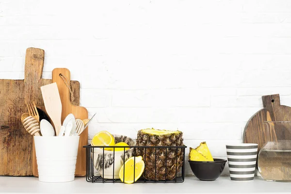 Кухонна полиця спосіб життя білий фон зі свіжими лимонами, ананасами, кухонними інструментами, побутовою технікою, подрібненими дошками, кошиками для зберігання. Екологічно чисте життя. Стиль будинку, мінімалізм, здорове харчування — стокове фото