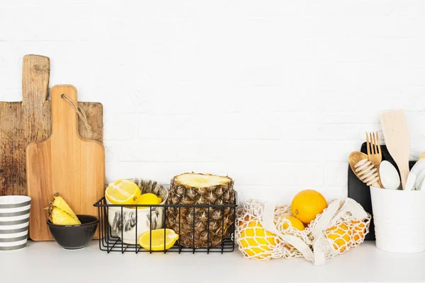 Mutfak raf organizasyonu meyve çatal bıçak takımı. Ev stili minimalizm sıfır israf. Ananas sepetleri, portakallar, beyaz tuğladan yapılmış limonlarla dolu bir hayat. Modern trend: — Stok fotoğraf