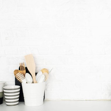 Depolama ürünleri için sepetlerle mutfak rafı, ananas, limon, bardakta çatal bıçak takımı, beyaz tuğla arka planda tahta doğrama. Moda tarzı ev skandalı minimalizm trendi. Boşluğu kopyala