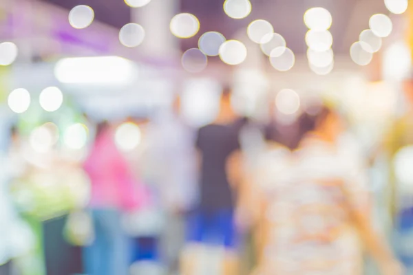 Suddig bakgrund: skara människor i expo mässan med bokeh ligh — Stockfoto