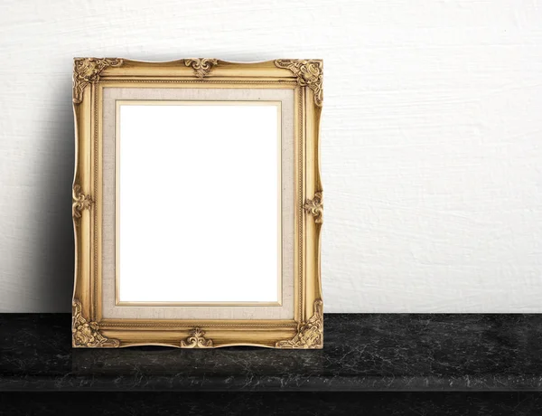 Blank Gold victorian picture frame on black marble table at whit