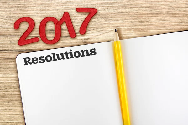 Vista superior de las resoluciones 2017 número rojo con cuaderno abierto en blanco — Foto de Stock