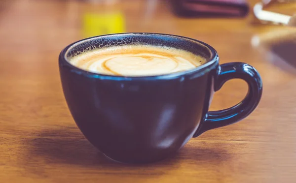 Kafede kahverengi ahşap masada siyah kahve fincanı — Stok fotoğraf