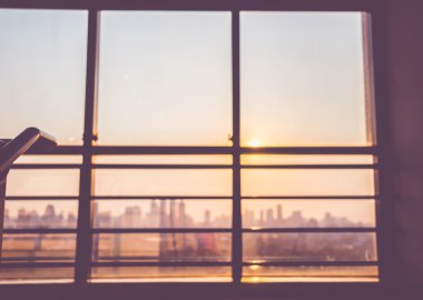 Arka plan günbatımı zamandan beri şehir v penceresine bakarak bulanık,