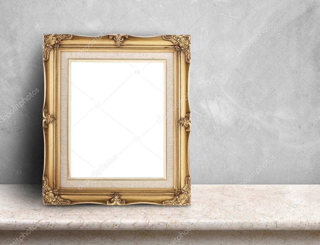 Blank Gold victorian picture frame on cream marble table at grey