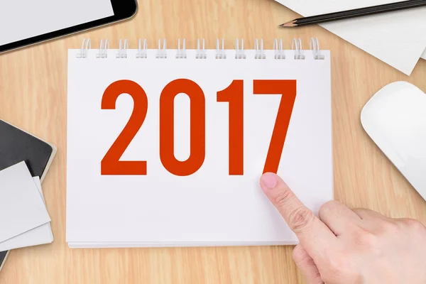 Hand point at 2017 year number on notebook and technology device — Stock Photo, Image