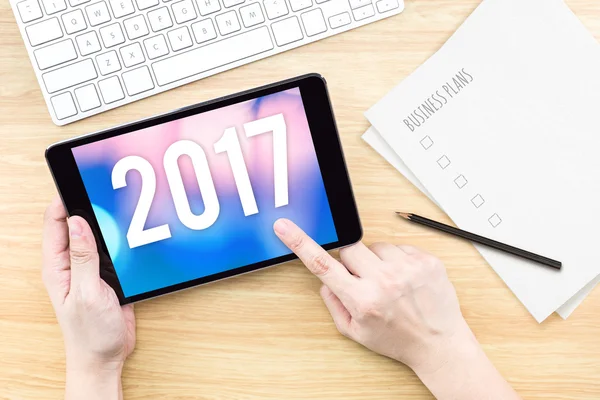 Hand touch tablett med 2017 år nummer på skärmen med business — Stockfoto