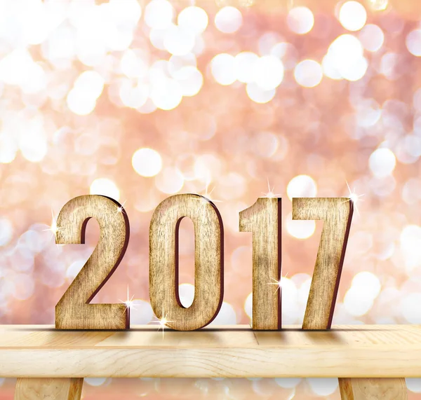 2017 år trä nummer på bord av trä med rosa mousserande bokeh wa — Stockfoto