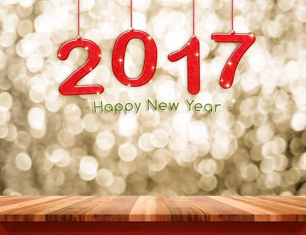 2017 new year hanging over plain wood table top with gold sparkl — Stock Photo, Image