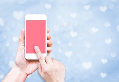 Bl üzerinde pembe ekranda parmak değmek ile cep telefonu tutan el