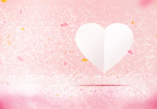 Papel corazón blanco flotando en la sala de brillo brillante rosa pastel —  Fotos de Stock