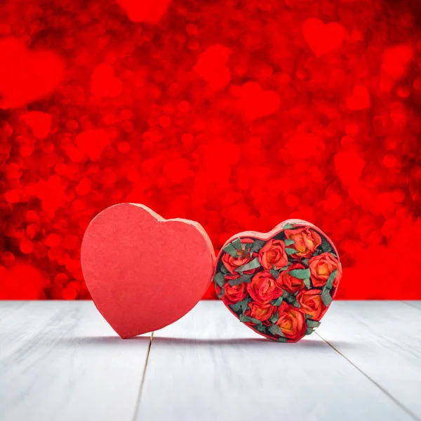 Boîte en forme de coeur avec des roses rouges à l'intérieur sur le dessus de table en bois blanc à — Photo