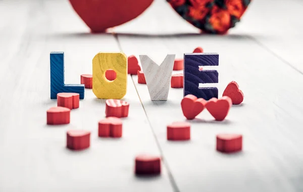 Palabra de amor de madera con corazón rosa sobre mesa vintage blanca, Love v — Foto de Stock