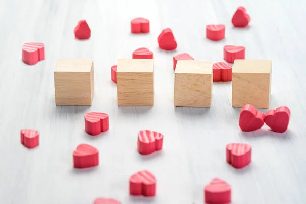 Stack of blank wood cube with group of mini red heart on white r — Stock Photo, Image