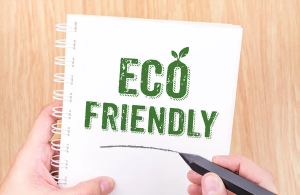 Eco friendly word on white ring binder notebook with hand holdin — Stock Photo, Image