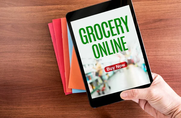 Ovanifrån av handen håller tablett med livsmedelsbutiker online word med ic — Stockfoto