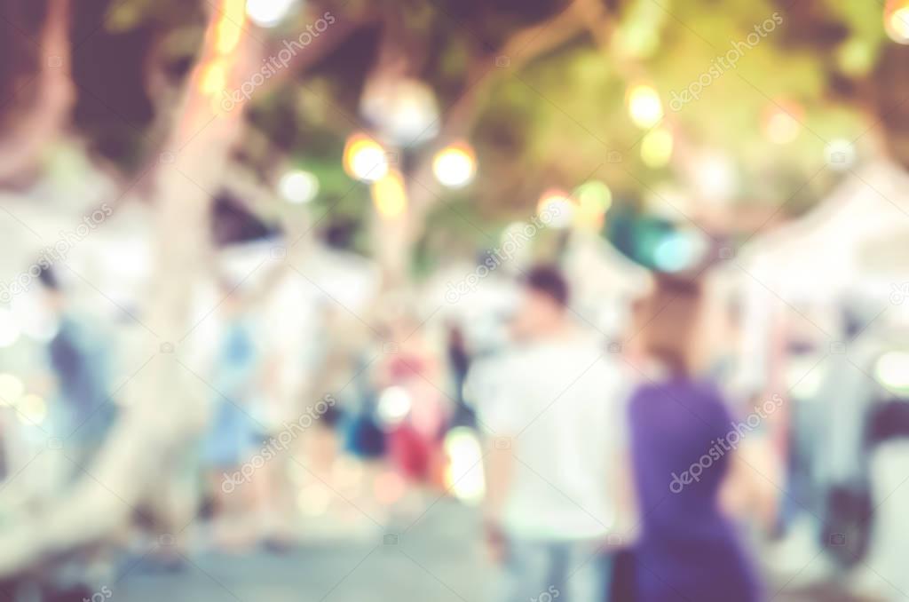 Blur background of people shopping at night market fair at stree