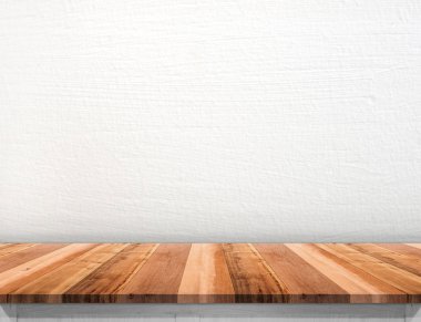Kahverengi ahşap masa üstü beyaz beton duvar ile alay için boş. 