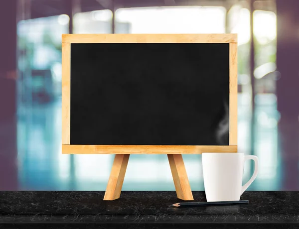 Blackboard with easel on black marble table top with blur abstra — Stock Photo, Image