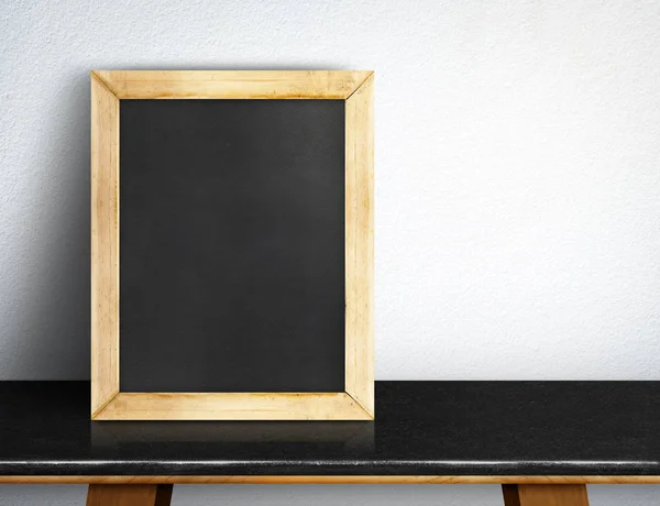 Leeg schoolbord op zwart marmeren tafel op witte tegel muur, d — Stockfoto