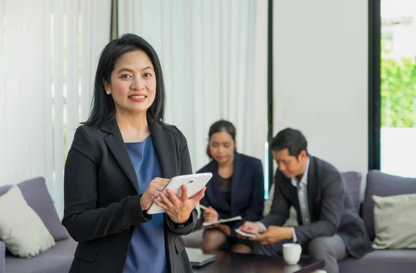 Empresa líder utilizando tableta con equipo en reunión corporativa —  Fotos de Stock