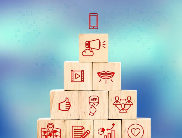 Mobile marketing feature icon on wood cube pyramid with blur blu