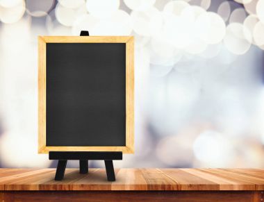 Blackboard şövale üzerinde bulanık kahve dükkanı backg, ahşap masa ile
