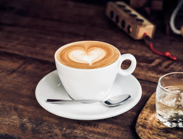 Vintage filtrado, taza de café blanco con forma de corazón arte latte en — Foto de Stock
