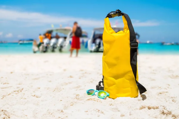 Żółta wodoodporna torba na ramię z okulary przeciwsłoneczne na plaży piasek o — Zdjęcie stockowe