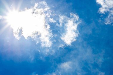 beyaz bulut ve mavi gökyüzü ile sun ray arıyor