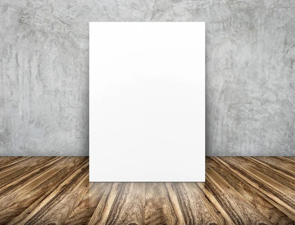 Cartel de papel blanco en blanco apoyado en la pared de hormigón sobre un floo de madera — Foto de Stock