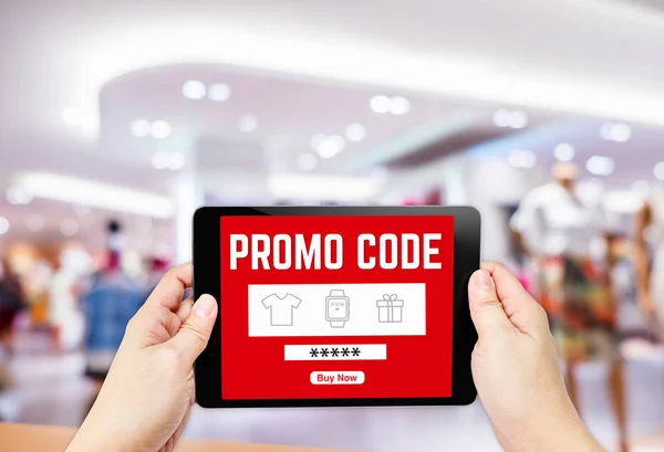 Deux main tenant la tablette avec le mot de code promo et acheter maintenant bouton , — Photo