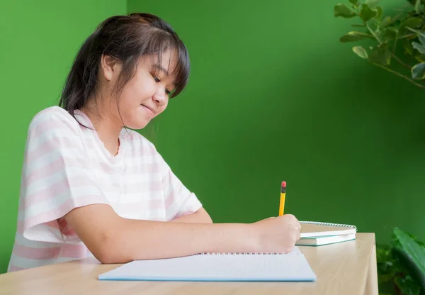 Asiático joven adolescente chica escritura tarea en escuela biblioteca tab —  Fotos de Stock