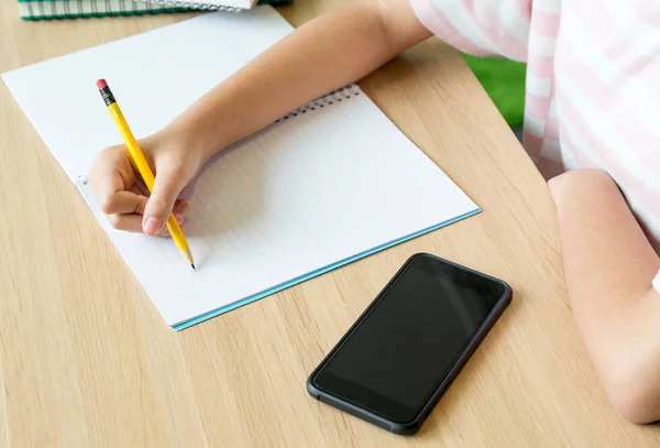 De cerca la mano de la chica adolescente aprendiendo en línea con el teléfono móvil —  Fotos de Stock