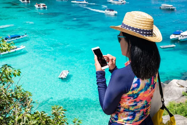 Мандрівник жінка з барвистим купальником використовує мобільний знімок — стокове фото