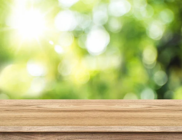 Leere braune Holztischplatte mit Sonne und verschwimmen grünen Baum Bokeh ba — Stockfoto