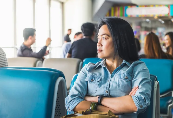 Asiatisk kvinna väntar på flyg på flygplatsen för avresa — Stockfoto