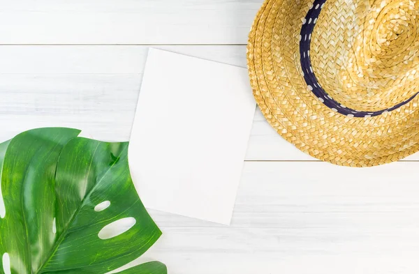 Cartão de papel branco em branco na vista superior da mesa de madeira com chapéu de palha e — Fotografia de Stock