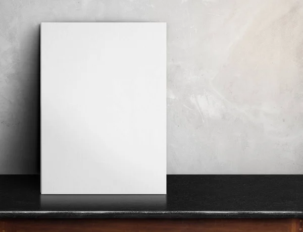 Cartel de papel blanco en blanco sobre mesa de mármol negro en hormigón gris — Foto de Stock